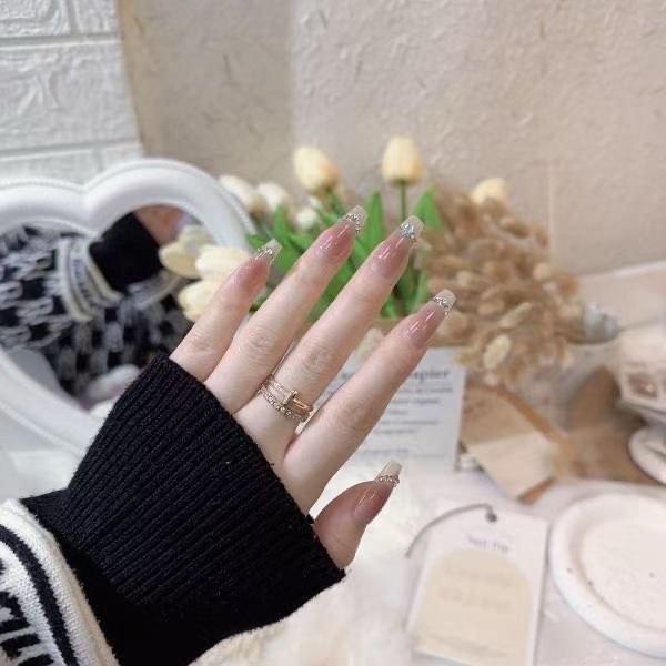Light-colored nail art, including off-white, light pink, and light blue, makes h